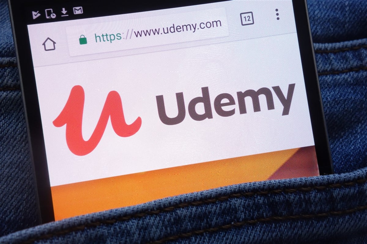  photo of udemy logo displayed on mobile device in jeans pocket                    