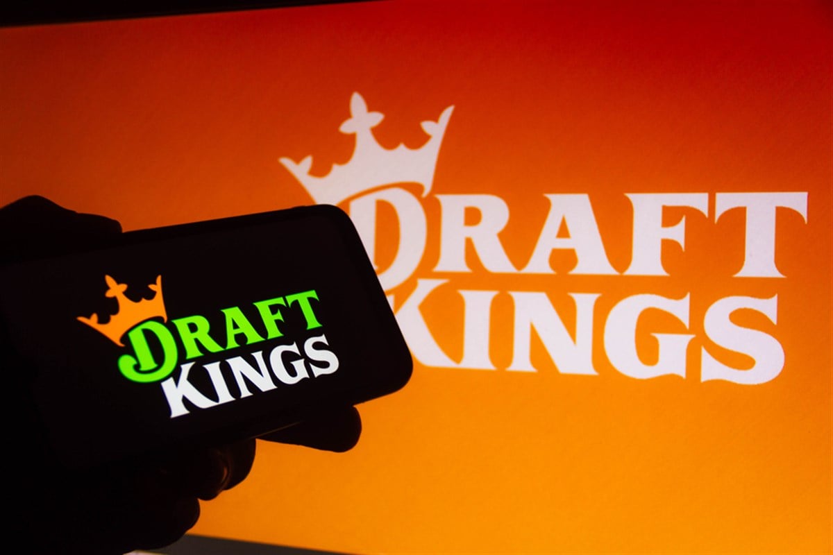 DraftKings on a smartphone with the DraftKings logo in the background