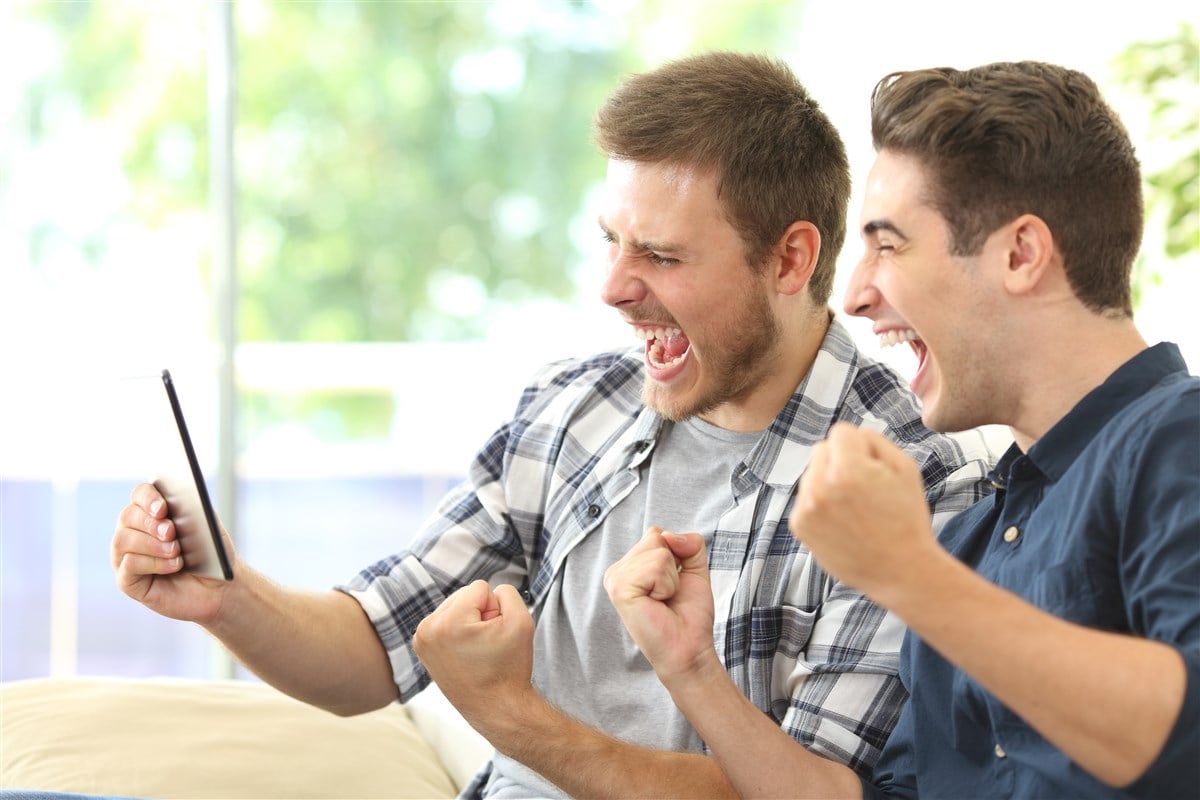 Two men watching sports on tablet