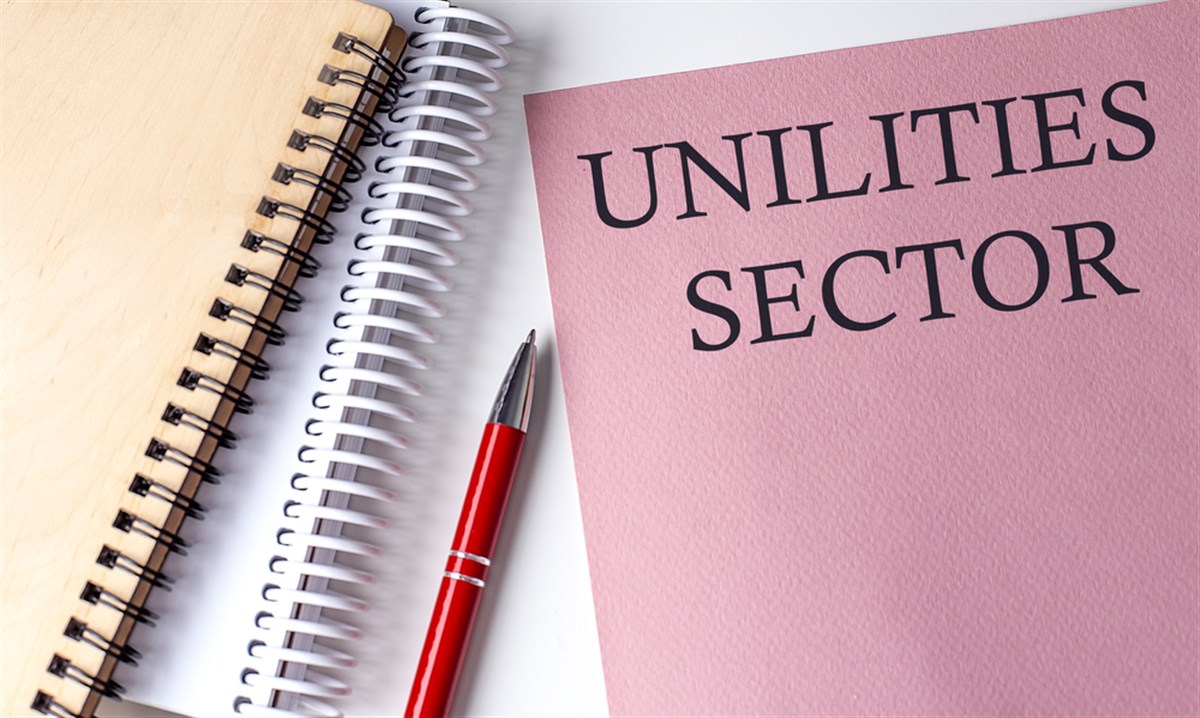 Utilities Sector word on pink paper with office tools on white background