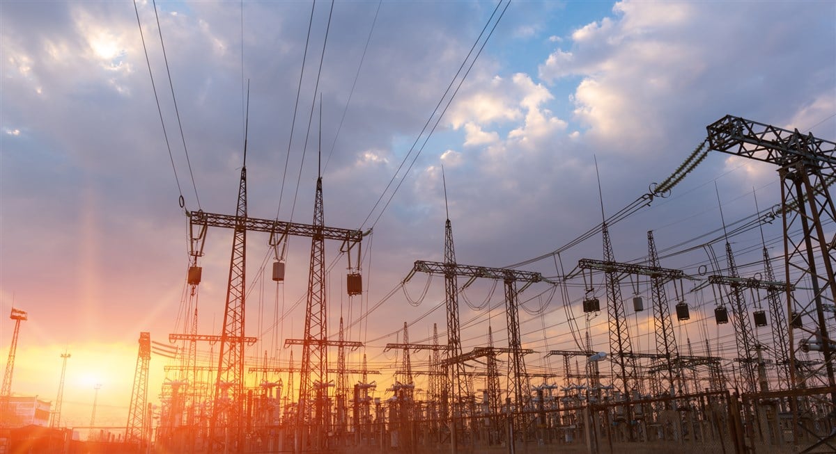 High-voltage power lines at sunset or sunrise. High voltage electric transmission tower.