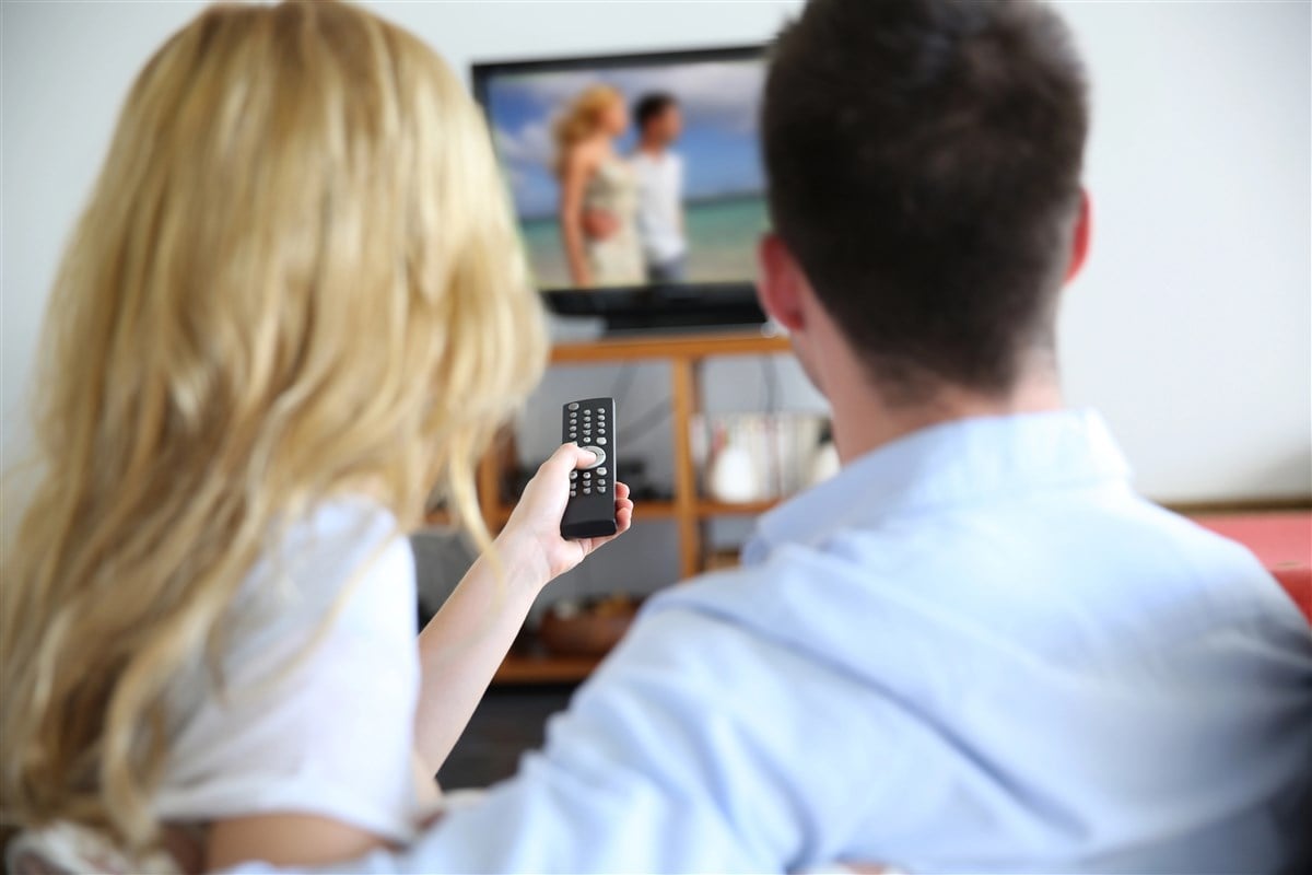 photo of back view of couple watching television