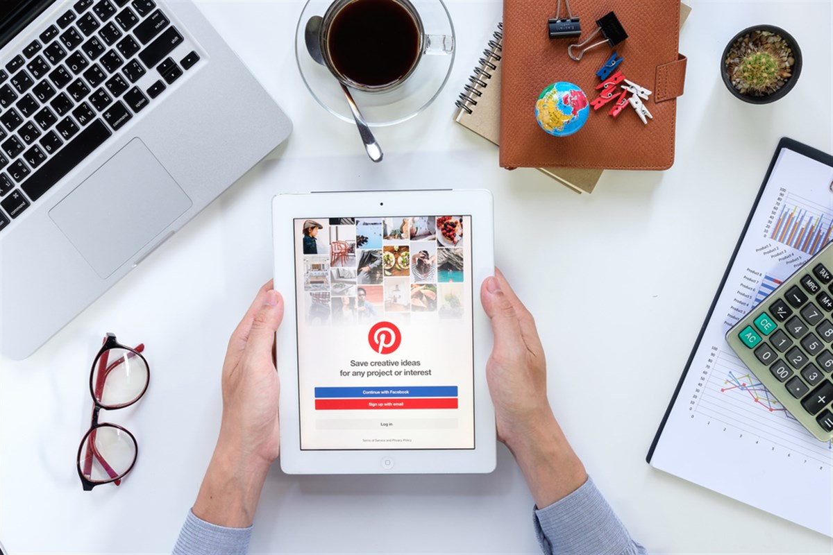 Photo of a deskscape, where someone a Pinterest mobile user holding a table. Pinterest Prospers From AI Boosting Shop-Ability and Relevance.