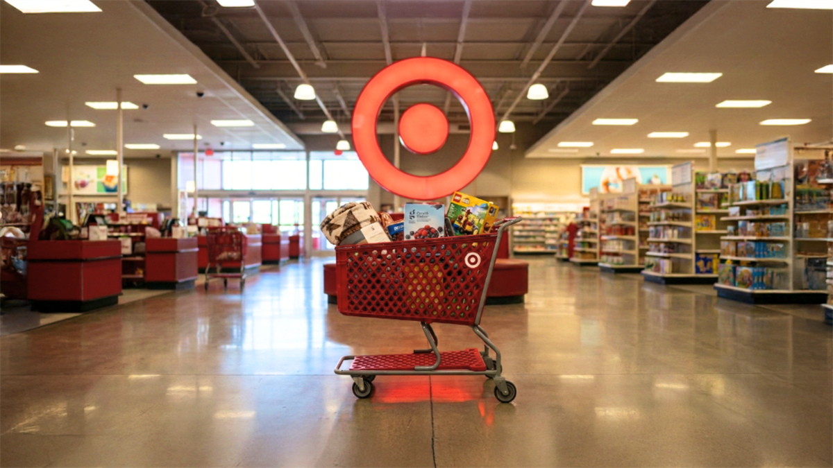Target shopping cart filled with household goods under the bright Target logo, reflecting consumer spending trends.