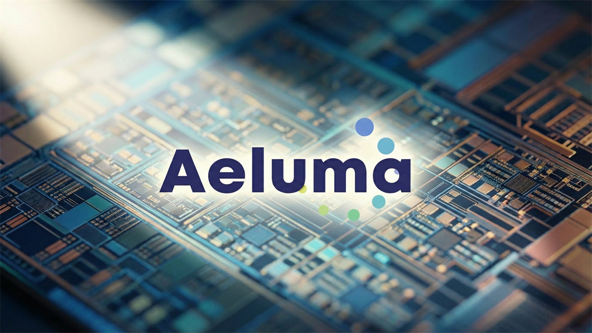 Aeluma logo over a close-up semiconductor chip design background, illustrating photonics and compound semiconductor tech.