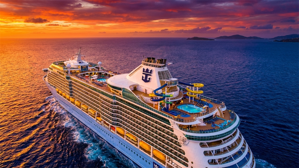 Royal Caribbean cruise ship sailing at sunset, highlighting strong leisure travel demand and cruise line stock outlook.