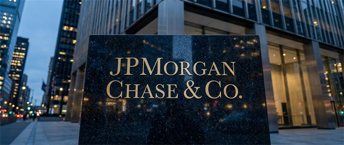 A JPMorgan Chase & Co. nameplate sign stands outside the company's office building at dusk.
