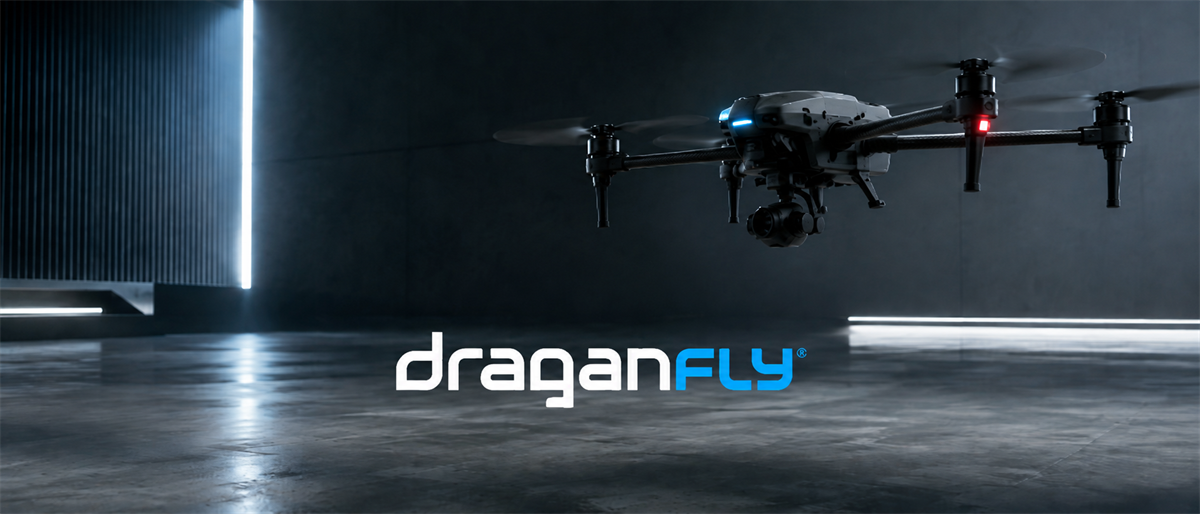 A drone with a camera gimbal flies in a dark room above the Draganfly company logo.