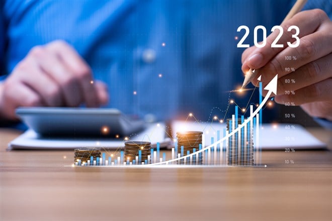 Businessman planning 2023 business growth on desk with virtual hologram chart graph. Calculate income and profit on investments and an increase in the indicators of positive growth, Return on Stocks