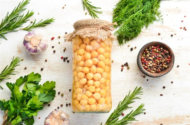 Pickled chickpeas in a glass jar. Turkish peas. Food stocks. Top view.
