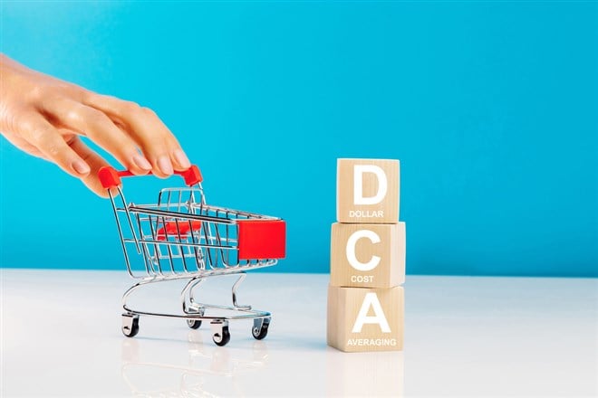 The text DCA written on wooden cubes with woman pushing a stroller. What is dollar cost averaging? Learn more.