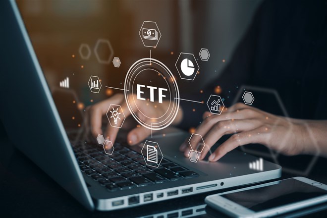 Person working on computer on the ETF exchange traded fund; learn about the best fintech ETFs