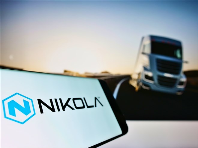 nikola logo on tablet with blurred truck in background