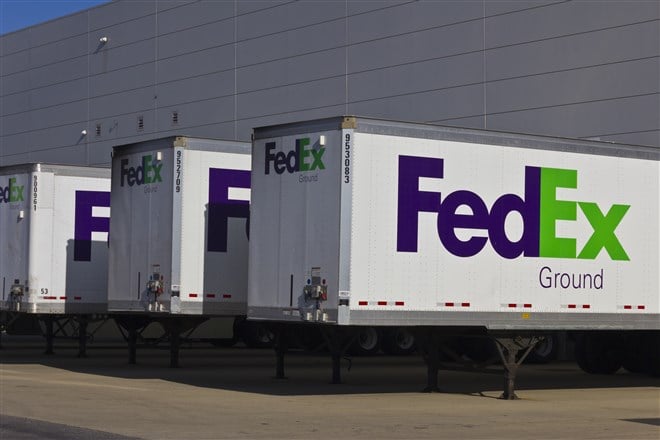 series of FedEx trucks at loading dock