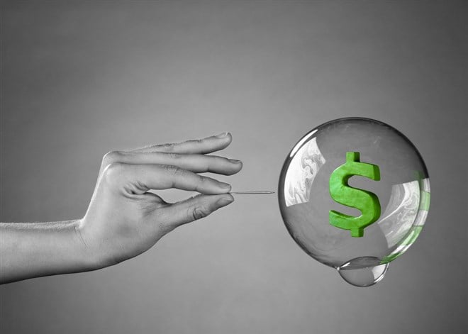 What is an economic bubble? Image of bubble with dollar sign being popped
