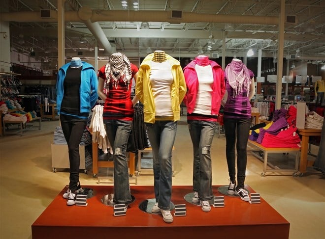Teenage clothing on display in store; learn how to invest in apparel stocks
