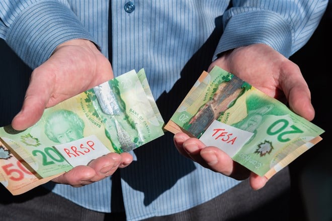 Close-up of man's hands holding Canadian cash for RRSP and TFSA investments