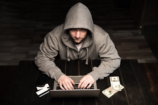 photo of hacker in brown hooded sweatshirt