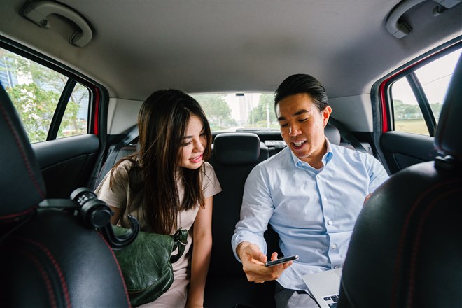 asian couple in back of car showing ride sharing