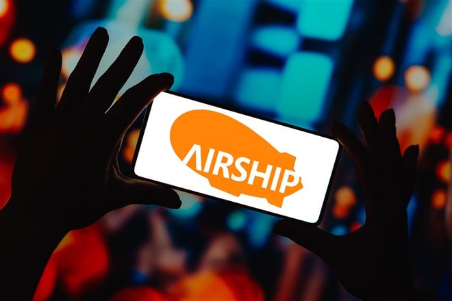 Photo of hands holding mobile device displaying Airship AI logo
