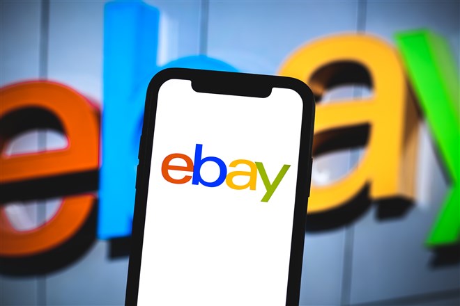 photo of ebay logo on mobile device with larger ebay logo in the background