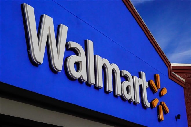 Photo of entrance to Walmart store with prominent logo under blue skies
