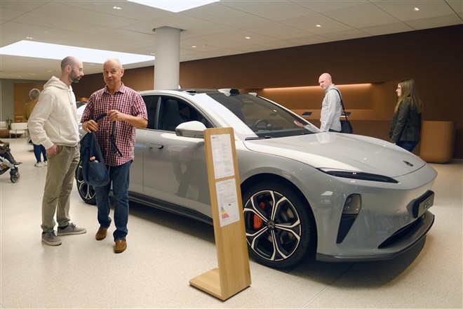 photo of Nio sedan in showroom with customers 