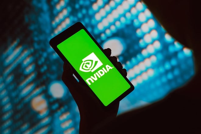 Photo illustration of hand holding mobile device with Nvidia logo on the screen