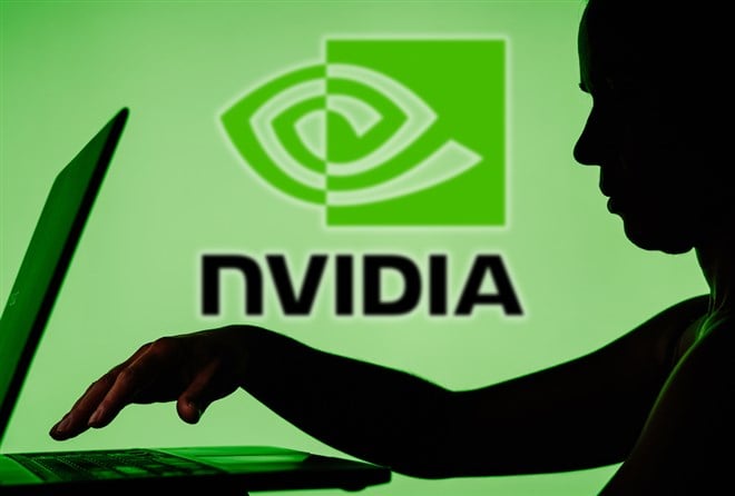 Photo: Nvidia logo in the background of a silhouette of a person using a laptop. NVIDIA enters a market correction - is it an opportunity or a concern?
