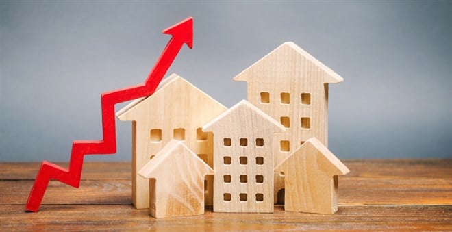 Photo: Miniature wooden houses and red arrow up, indicating the growth of rent and mortgage rates. 