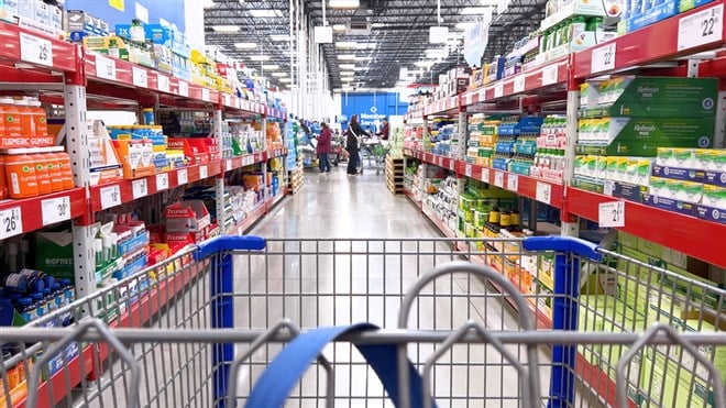 Photo showing a shopping cart in an aisle at a warehouse shopping store. PriceSmart could be the smartest buy of the year