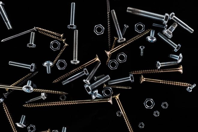 Photo of nuts and bolts against black backdrop. Dividend Aristocrat Fastenal is on sale, Buy it While it’s Down