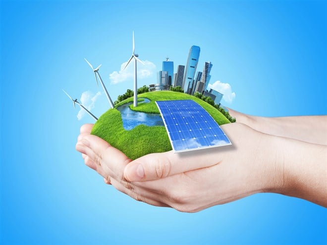 Photo of a person holding an imagined photo of a city skyline and greenspace with windmills and solar power. NextEra's stock price could rise as oil prices make alternative energy more attractive.