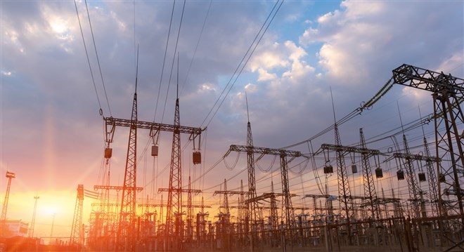 High-voltage power lines at sunset or sunrise. High voltage electric transmission tower.