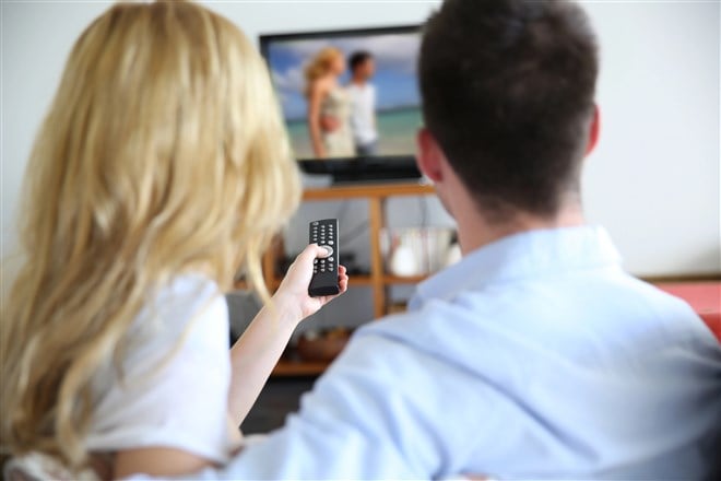 photo of back view of couple watching television