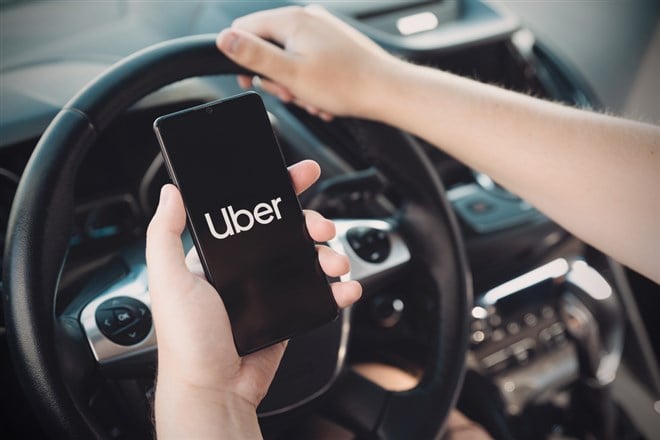 Uber driver holding smartphone in car