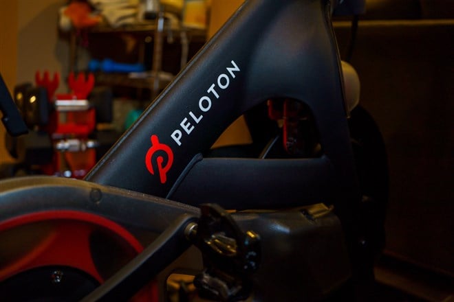Photo of the Peloton logo on the base of flagship stationary exercise bike. Is Peloton a Buyout Target? Analyzing Its Stock Value & Potential.