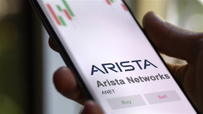 closup photo of hand holding mobile device with Arista Networks name and logo displayed
