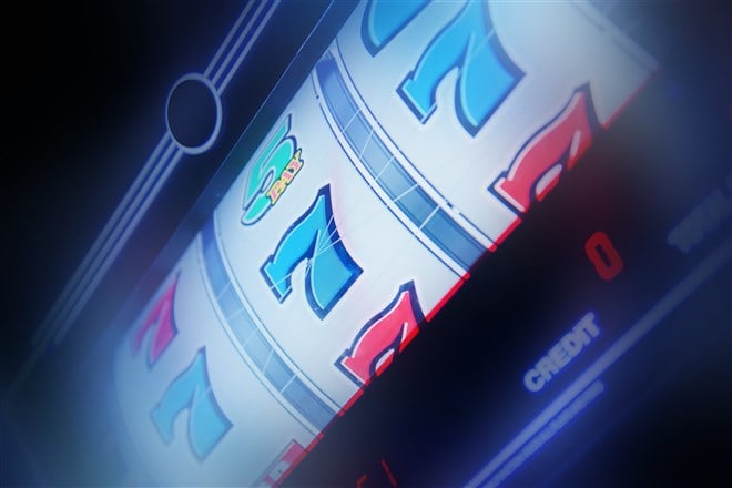 closeup photo of slot machine displaying three 7's symbol for jackpot