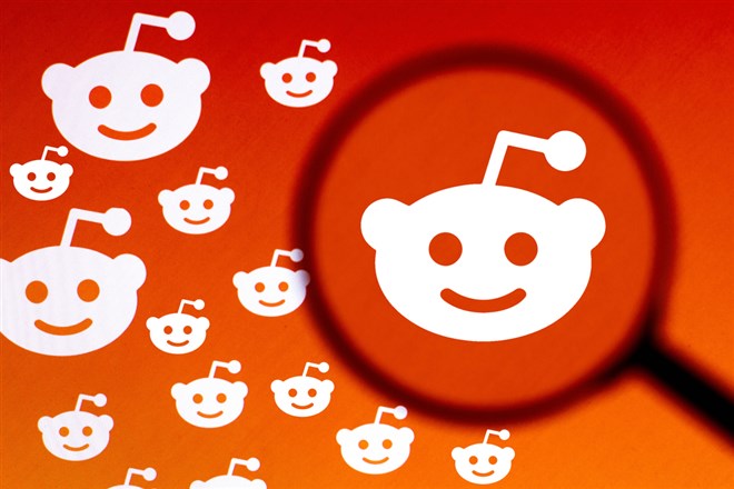 In this photo illustration the Reddit logo is seen on a computer screen through a magnifying glass