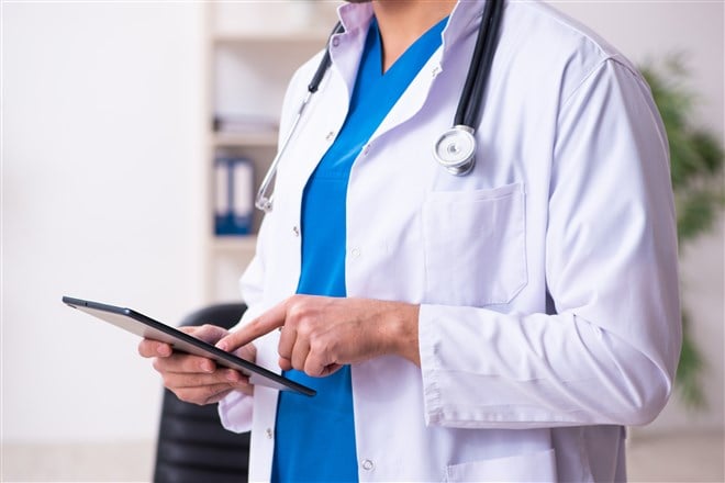 photo of doctor holding tablet suggesting telehealth visit