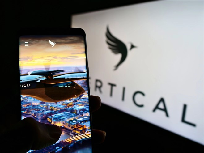 Smartphone with a picture of VX4 aircraft with Vertical Aerospace logo in background.