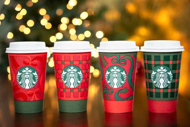 Starbucks holiday cups displayed with festive lights highlight seasonal product demand amid the company’s ongoing turnaround strategy.
