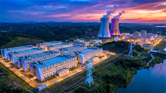 Aerial view of nuclear power plant and adjacent data-center campus at sunset, highlighting rising electricity demand.