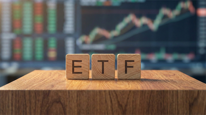 Wooden blocks spelling “ETF” on a desk with rising stock chart in the background, symbolizing ETF market growth.