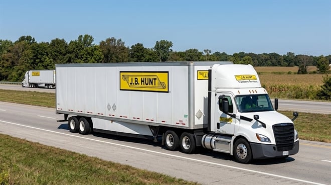 A J.B. Hunt Transport Services semi-truck and trailer travel along a rural highway.
