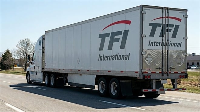 A TFI International branded semi-truck and trailer traveling on a highway.