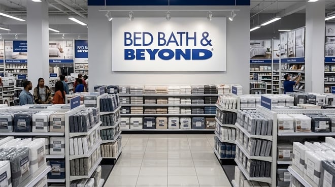 Interior of a Bed Bath and Beyond retail store with shoppers browsing shelves stocked with bedding products.