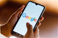 Google logo on smartphone with hands