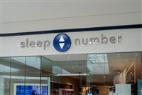 photograph of storefront with sleep number name and logo